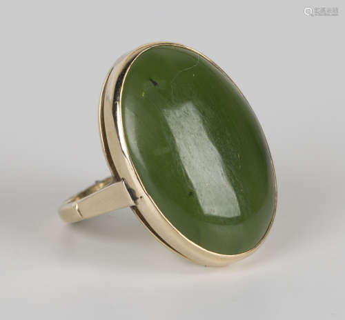 A gold ring, mounted with an oval cabochon nephrite, detailed '9ct', ring size approx M1/2.Buyer’s