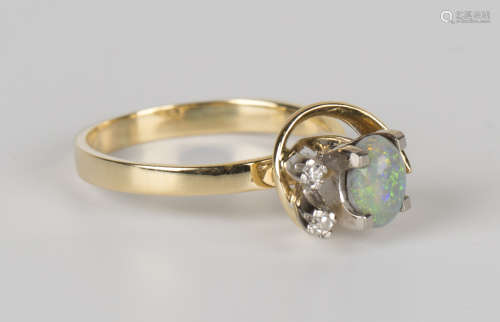 A gold, opal and diamond ring, claw set with an oval opal and two circular cut diamonds in an