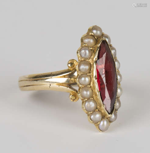 A gold, garnet and half-pearl set ring, mounted with a marquise cut garnet within a surround of