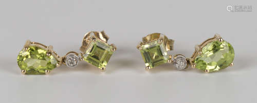 A pair of gold, peridot and diamond pendant earrings, each claw set with a pear shaped peridot