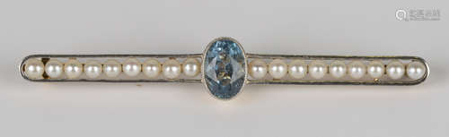 A gold, aquamarine and seed pearl bar brooch, collet set with the oval cut aquamarine between two