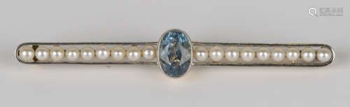 A gold, aquamarine and seed pearl bar brooch, collet set with the oval cut aquamarine between two