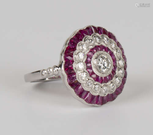 A platinum, diamond and ruby cluster ring, collet set with a principal circular cut diamond within a