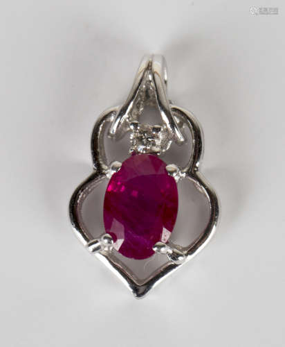A white gold, ruby and diamond pendant, claw set with an oval cut ruby beneath a circular cut