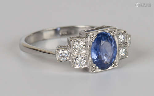 A platinum, sapphire and diamond ring, mounted with an oval cut sapphire in a square setting between