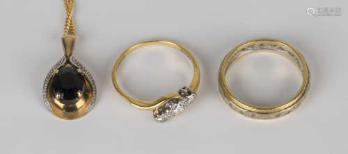 A gold, platinum and diamond set three stone ring, mounted with circular cut diamonds in a cross-
