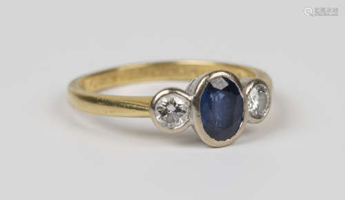 An 18ct gold, sapphire and diamond three stone ring, mounted with the oval cut sapphire between