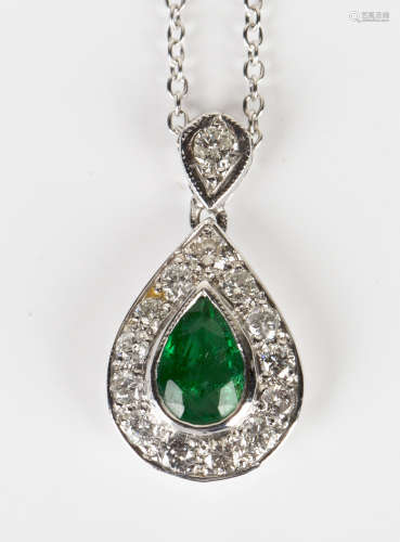 An emerald and diamond drop shaped cluster pendant, mounted with a pear shaped emerald within a