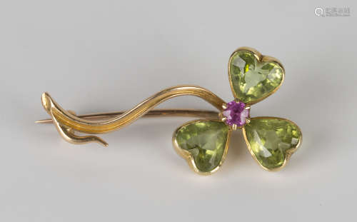 A gold, peridot and pink gemstone set brooch, designed as a trefoil spray, mounted with a cushion