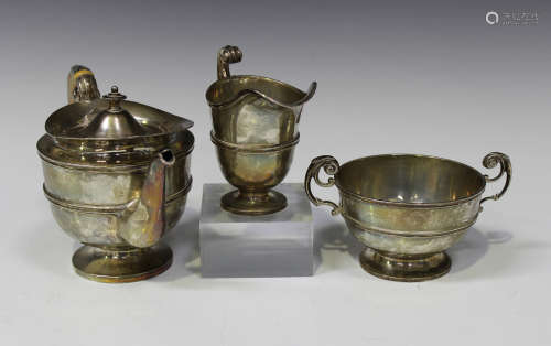 An Irish silver three-piece bachelor's tea set, each piece of circular girdled form with scroll