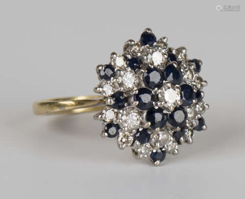 An 18ct gold, sapphire and diamond cluster ring, claw set with circular cut sapphires and