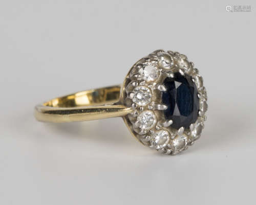 A gold, sapphire and diamond oval cluster ring, claw set with the oval cut sapphire within a