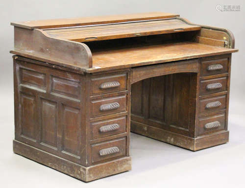 A George V oak roll-top desk, the tambour front revealing drawers, the pedestal drawers on plinth