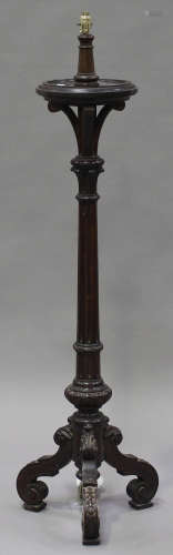 A Victorian oak bedpost lamp standard with carved decoration, the fluted column on tripod scroll