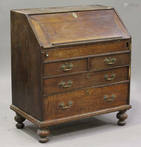 An 18th century oak bureau, the fall front enclosing a well above two short and two long drawers, on