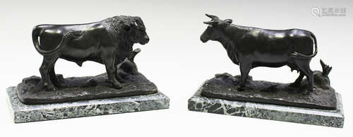 A pair of 20th century black patinated cast bronze models of bulls, both standing four square on