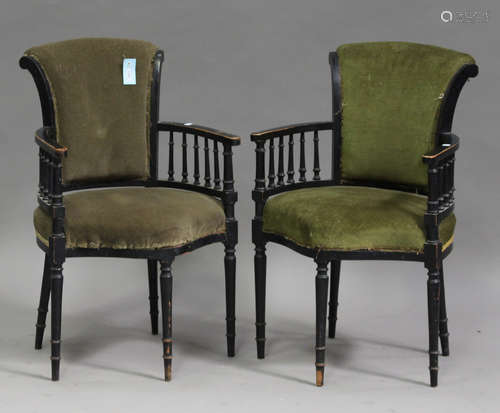 A pair of late Victorian ebonized tub back chairs, upholstered in green velour, on turned legs,