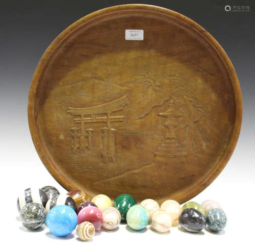 A mid-20th century Japanese circular wooden tray, carved in relief with a scene of the Itsukushima