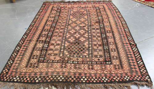 An Afghan kelhim carpet, late 20th century, the pale aubergine field with overall geometric panels