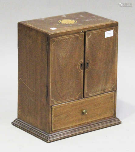 An Edwardian mahogany and boxwood inlaid smoker's cabinet, the hinged doors revealing drawers, on