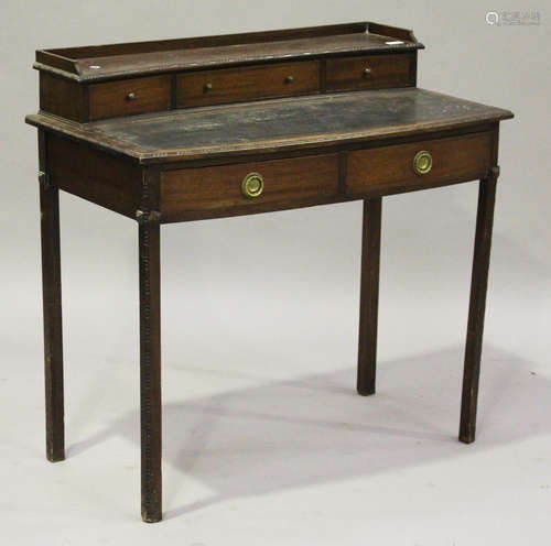 An Edwardian mahogany writing table with bead and reel moulded borders, fitted with three gallery