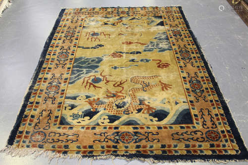 A Chinese rug, late 19th/early 20th century, the yellow field with two dragons chasing flaming