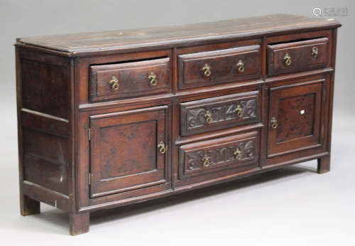 An 18th century provincial oak dresser base, fitted with five drawers and two cupboards, on stile