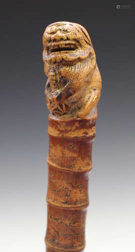 A late 19th century Chinese bamboo walking cane, the handle carved with Buddhistic lion, length 90.