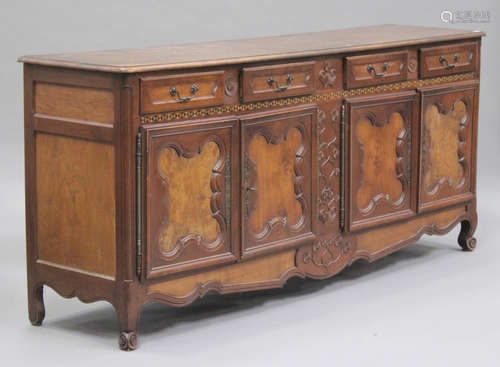 A 20th century French walnut enfilade sideboard with carved and inlaid decoration, fitted with