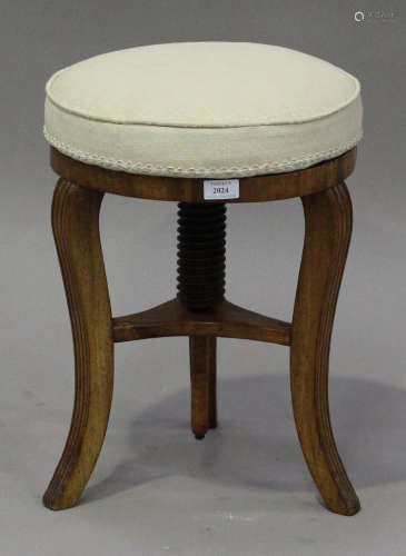 A 19th century rosewood revolving piano stool, the circular overstuffed seat raised on reeded