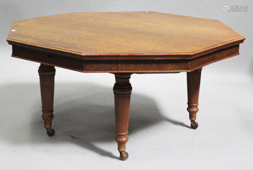 A large late Victorian oak extending dining table, the octagonal moulded edge top fitted with four