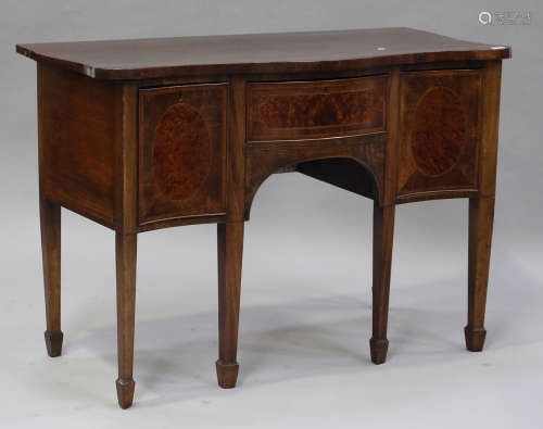 A George III mahogany serpentine fronted sideboard, fitted with three drawers with amboyna reserves,