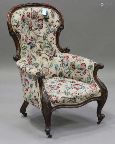 A Victorian mahogany showframe salon armchair with carved decoration, upholstered in floral