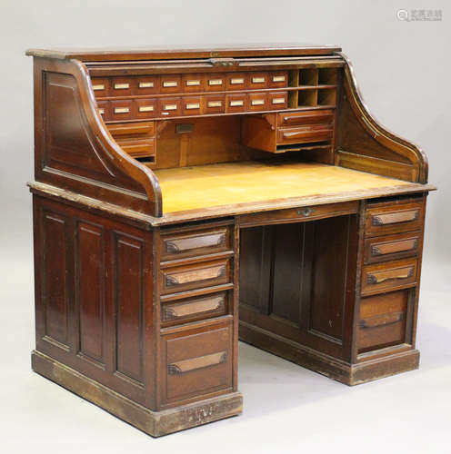 A George V walnut roll-top desk, the tambour front revealing pigeonholes and drawers, the pedestal