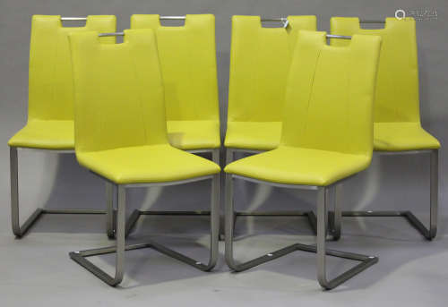A set of six modern yellow leather upholstered dining chairs, raised on cantilever supports,