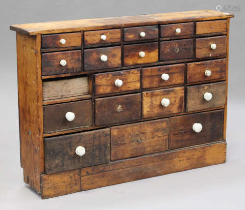 A Victorian pine bank of twenty-one drawers with white ceramic handles, height 98cm, width 156cm,