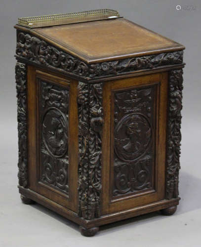 An early 20th century oak Davenport with overall Victorian Jacobean Revival carved panels, the