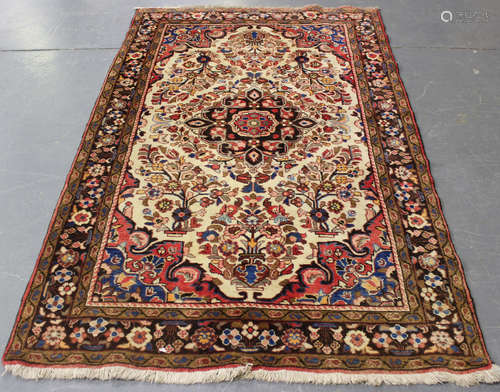 A Hamadan rug, North-west Persia, mid-20th century, the ivory field with a foliate medallion,