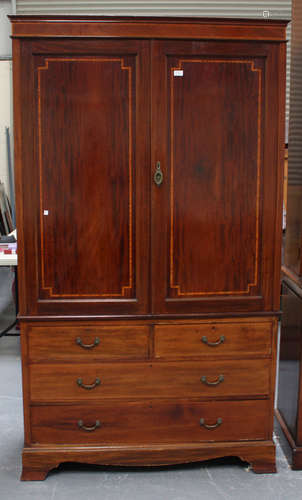 An Edwardian mahogany and satinwood crossbanded linen press, fitted with two panelled doors above