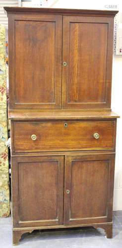 A George III oak secrétaire bookcase, the moulded top above a pair of panel doors, the fall front