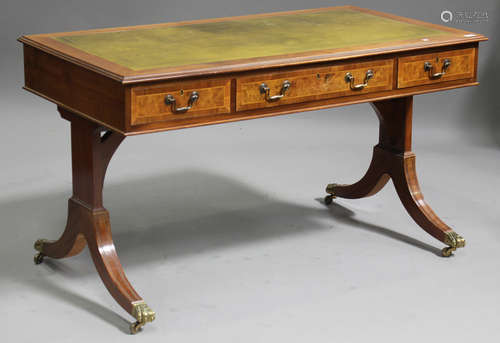 A 20th century reproduction walnut library table, the moulded top inset with a gilt-tooled green