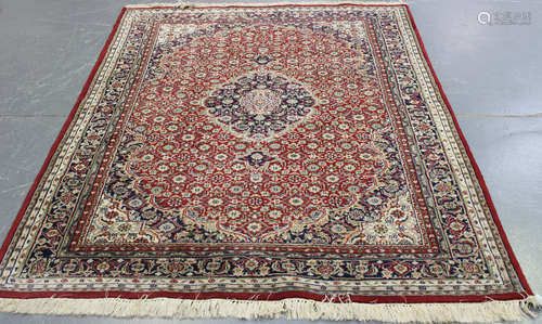 A large Indian rug, late 20th century, the red field with a foliate medallion, profusely supported