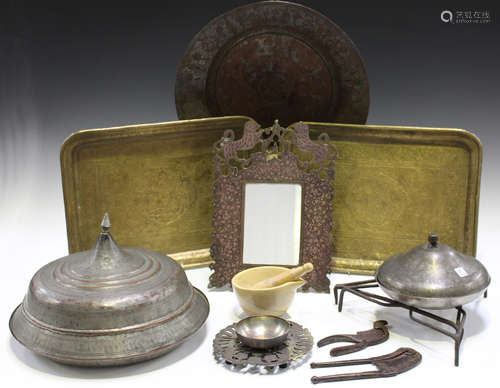 A group of mainly Eastern metalware, including an Indian engraved brass mirror frame, 31cm x 22cm,