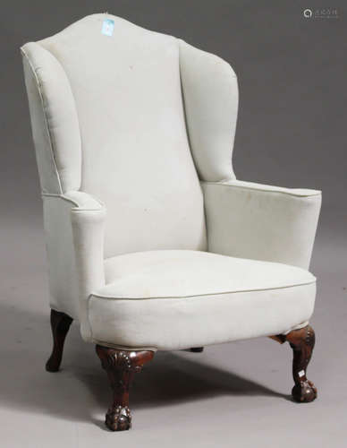 An early 20th century Queen Anne style wingback armchair, upholstered in a pale blue fabric, on