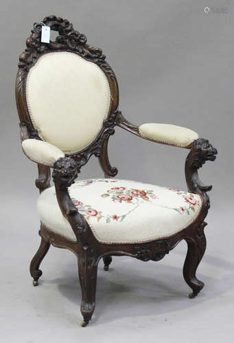 A Victorian walnut salon open armchair, the top rail carved with 'C' scrolls, the arms with carved