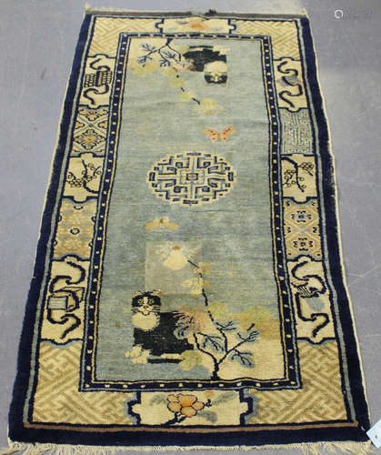 A Chinese rug, early 20th century, the pale blue field with a central medallion, two corners with