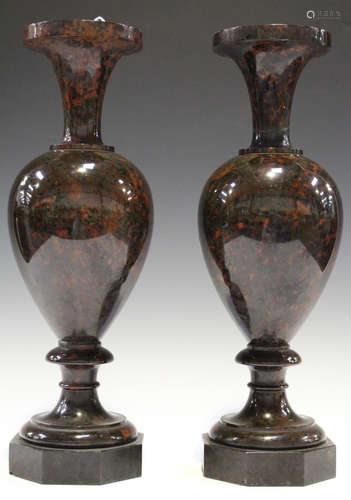 A pair of 19th century red serpentine ornamental urns, the ovoid bodies raised on octagonal bases,