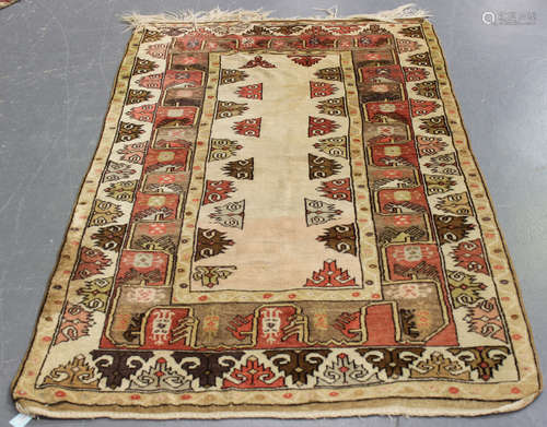 A Turkish rug, 20th century, the ivory field with pink and brown palmettes, within a complimentary