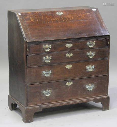 A George III oak bureau, the fall front revealing a fitted interior above four graduated long