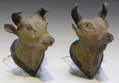 A pair of late 19th century terracotta wall mounted models of bulls' heads, probably Indian,